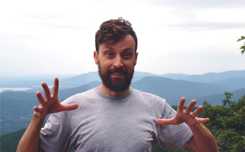 Matt McFarland gesturing in front of mountains and trees.
