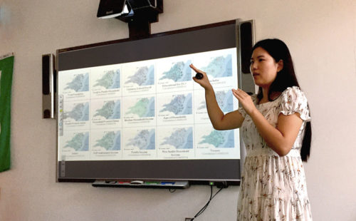 2018 Summer of Maps Fellow presenting her final maps on a screen.